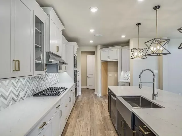 a large kitchen with granite countertop a stove and a sink