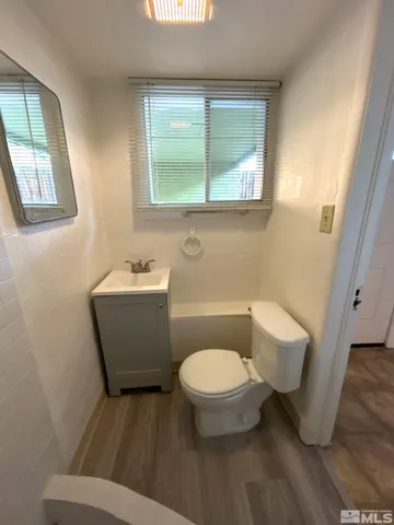 a bathroom with a toilet a sink and a window