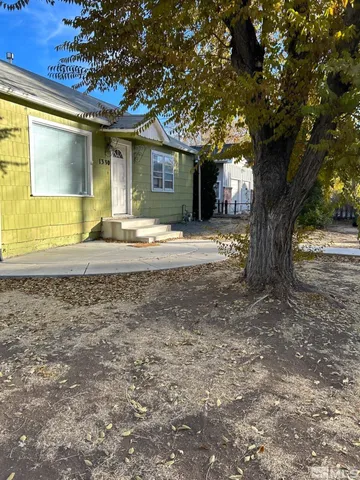 a view of a house with backyard and a tree