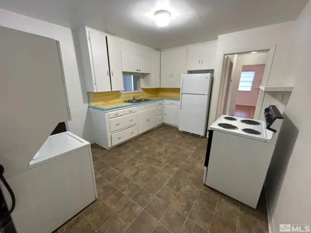 a kitchen with a refrigerator sink stove and cabinets