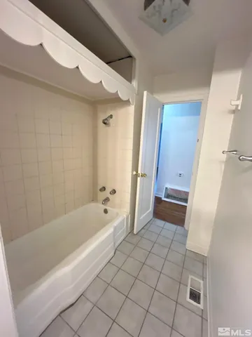a bathroom with a tub shower and a sink