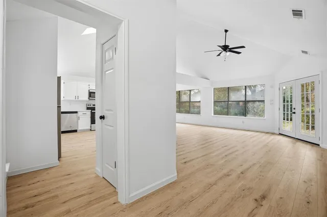 a view of empty room with wooden floor and windows