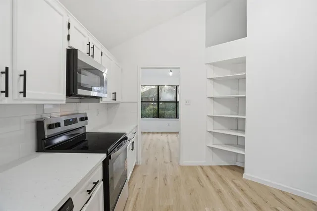 a kitchen with a cabinets and a stove top oven