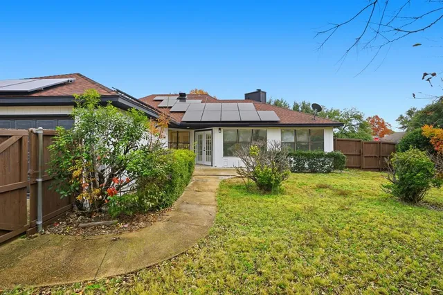 a view of a house with a yard and potted plants