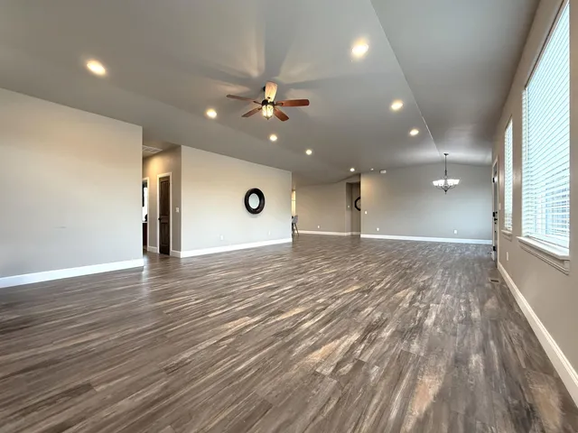an empty room with a fireplace and wooden floor