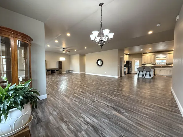 a kitchen with stainless steel appliances kitchen island granite countertop wooden floors and white cabinets