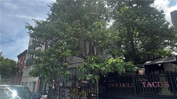 a street view with wooden fence and trees