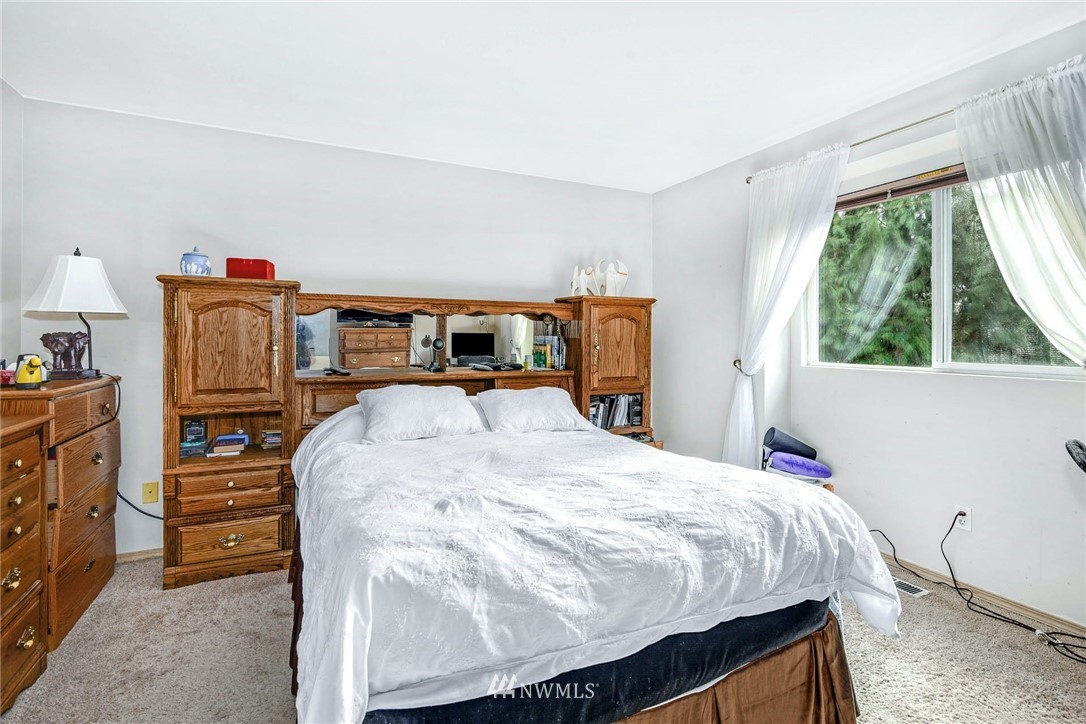 408 211th Place Southeast Bothell, WA 98021 - Photo 15 of 23 a bed sitting in a bedroom next to a window