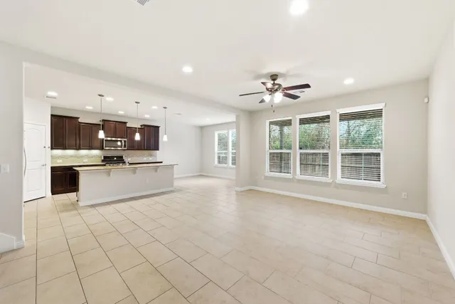 a view of kitchen with a sink dishwasher a kitchen island a stove and a sink