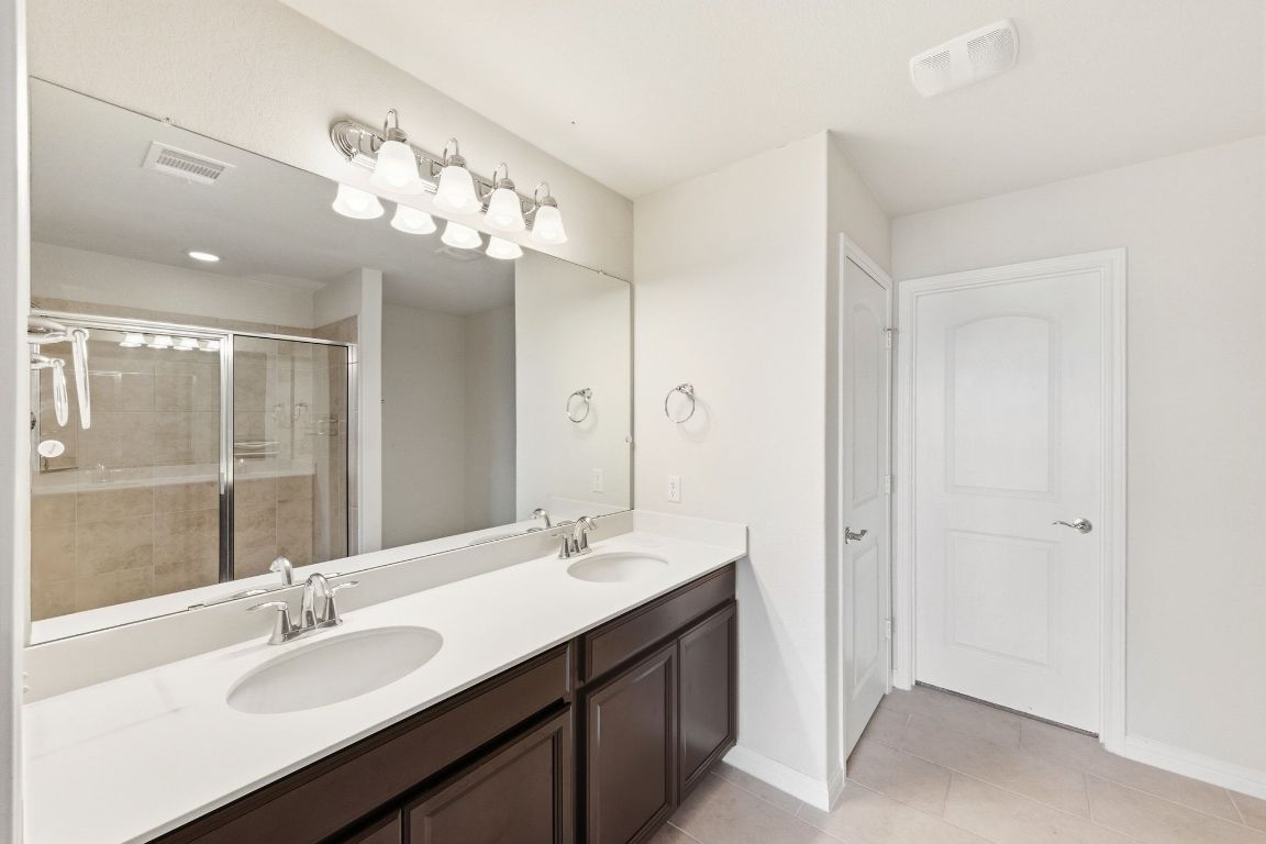 9415 Tanager Way Austin, TX 78748 - Photo 11 of 25 a bathroom with a sink double vanity and a mirror
