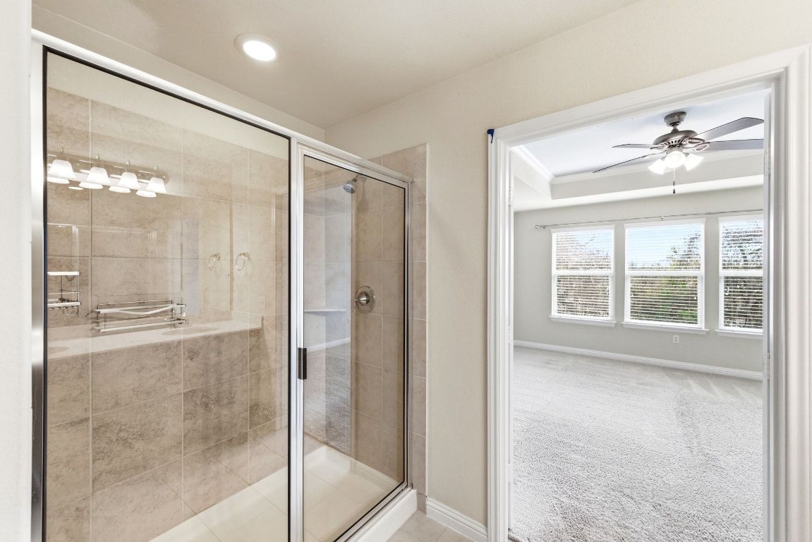 9415 Tanager Way Austin, TX 78748 - Photo 12 of 25 a bathroom with a glass shower door and a window
