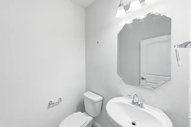 a bathroom with a sink mirror and toilet