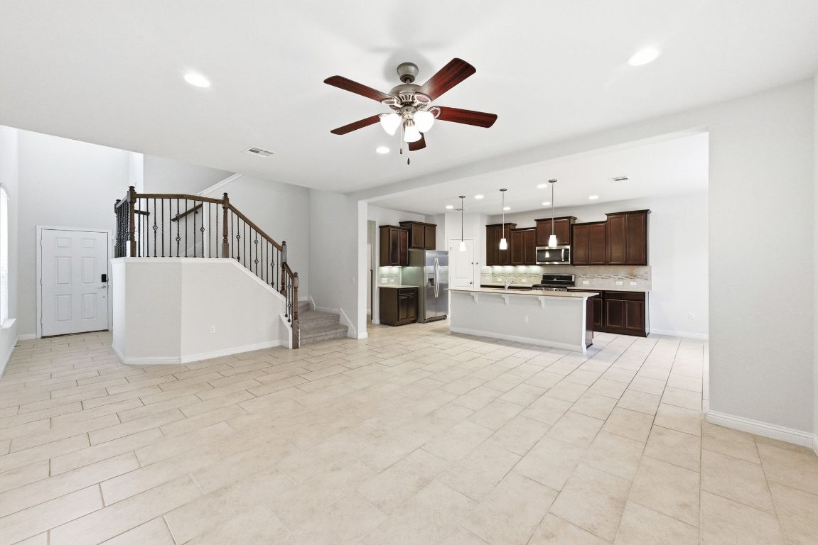 9415 Tanager Way Austin, TX 78748 - Photo 4 of 25 a view of a livingroom with a ceiling fan a kitchen view and a window