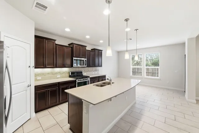a kitchen that has a sink a stove and a refrigerator