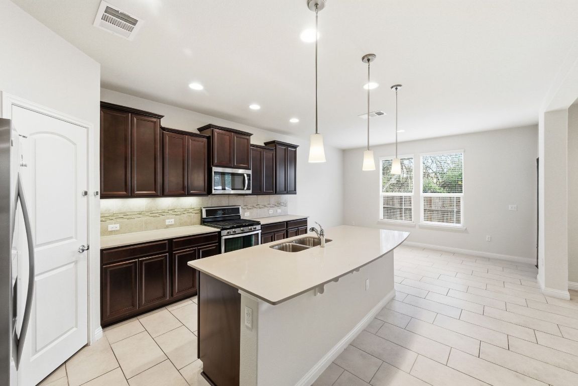 9415 Tanager Way Austin, TX 78748 - Photo 7 of 25 a kitchen that has a sink a stove and a refrigerator