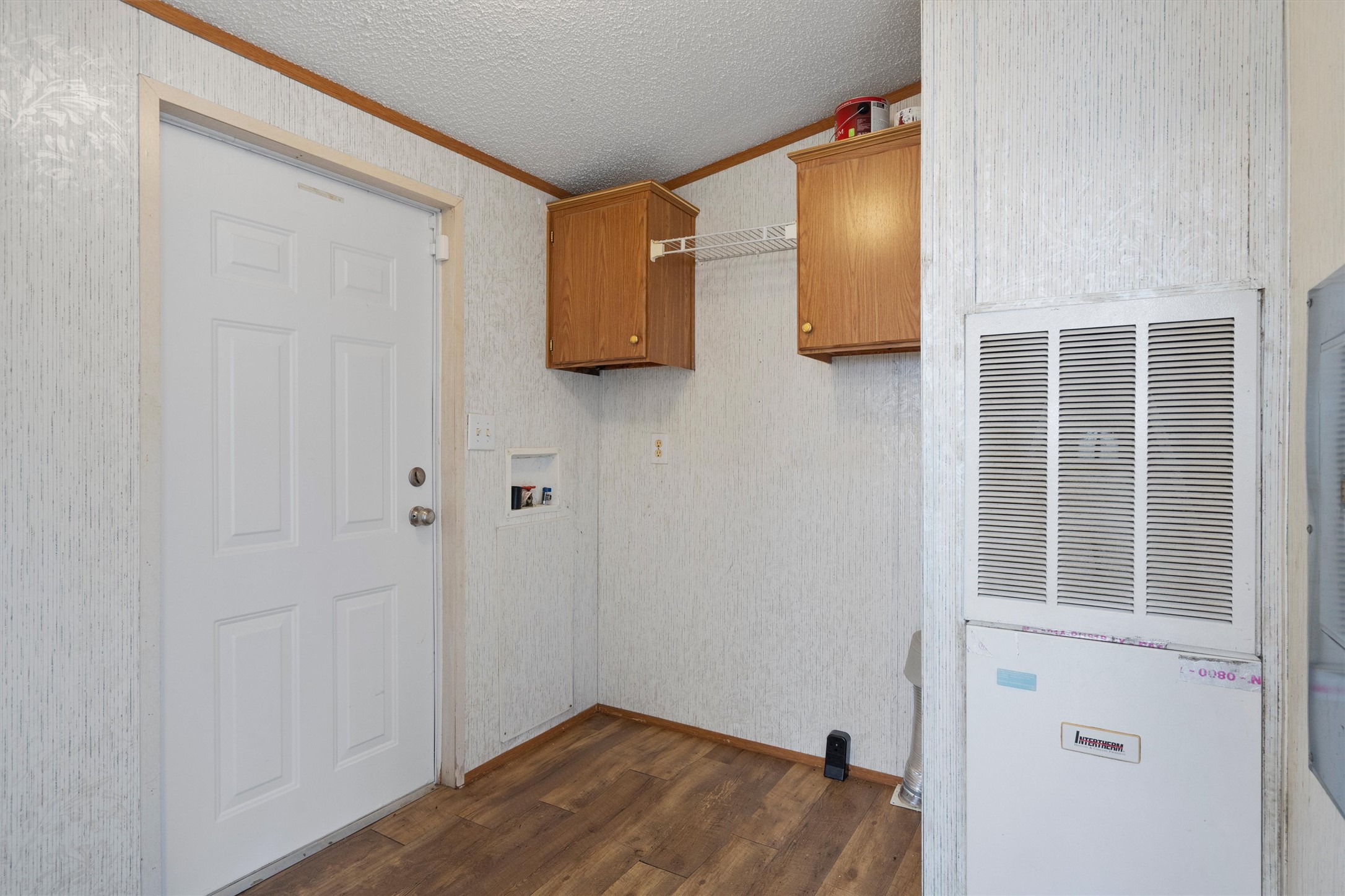 3075 Old Black Colony Road, Unit D Buda, TX 78610 - Photo 21 of 26 Functional utility space includes overhead storage cabinetry alongside durable wood-look flooring.