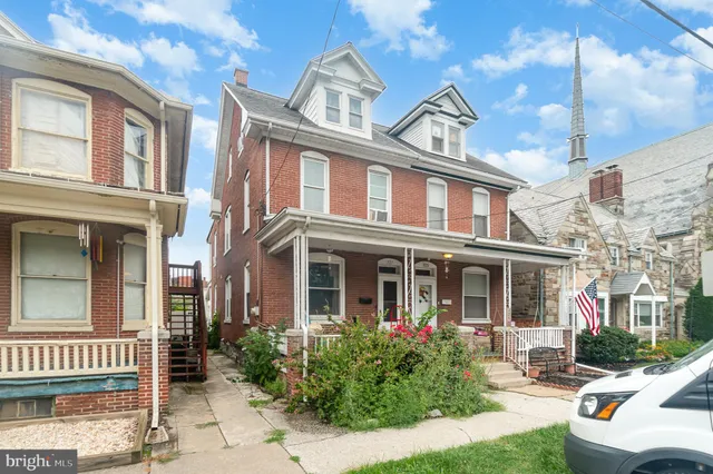 front view of a brick house with a yard