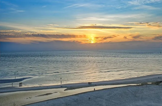 a kitchen with a sink a stove cabinets and a dining table