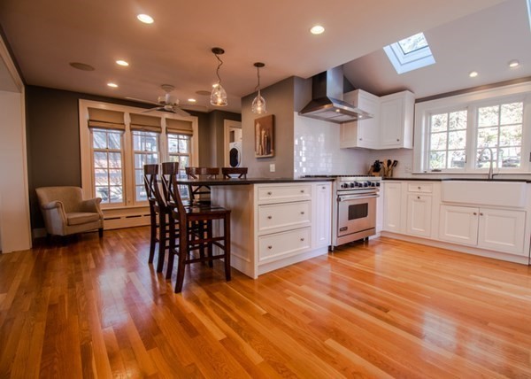 22 Allen Road Winchester, MA 01890 - Photo 4 of 38 a kitchen with stainless steel appliances granite countertop wooden floors stove top oven with dining table and chairs