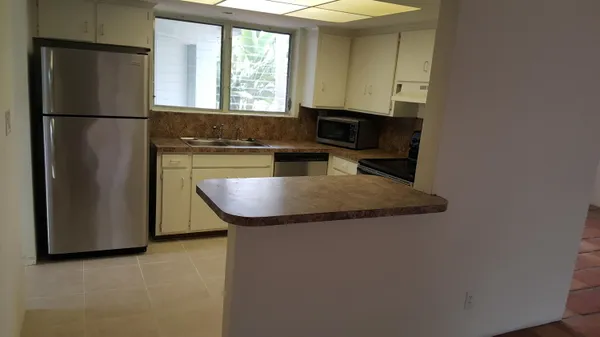 a kitchen with granite countertop stainless steel appliances a refrigerator microwave and sink