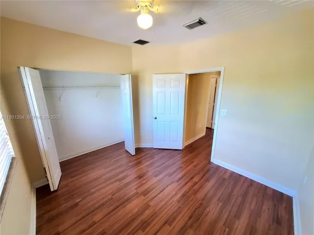 an empty room with wooden floor and door