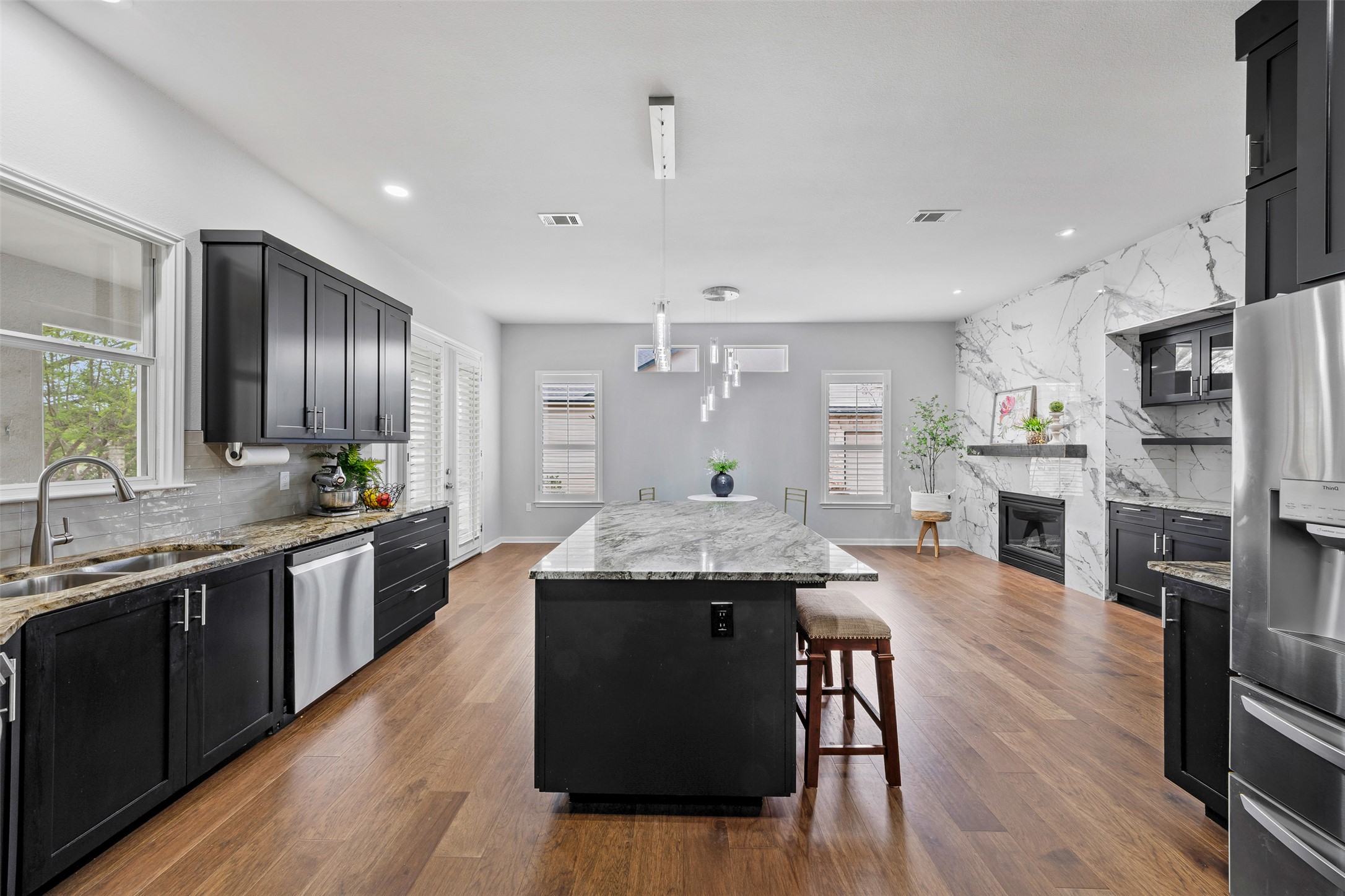 a kitchen with stainless steel appliances granite countertop wooden floors and wooden cabinets