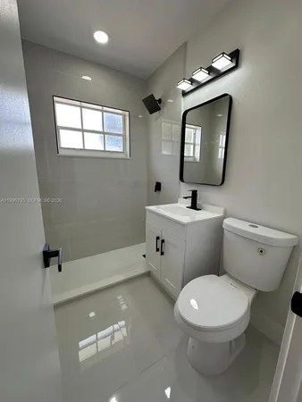 a bathroom with a toilet a sink and mirror