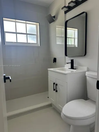 a bathroom with a toilet sink and mirror