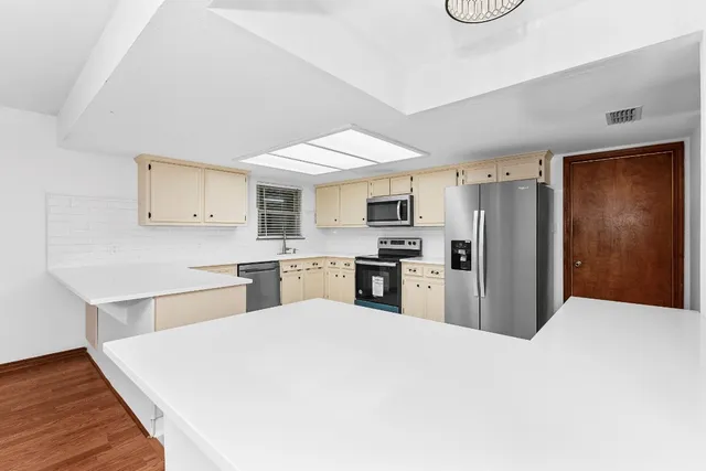 a kitchen with white cabinets stainless steel appliances and sink