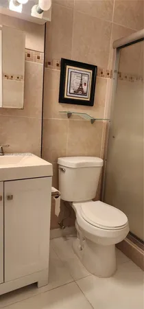 a white toilet sitting next to a shower