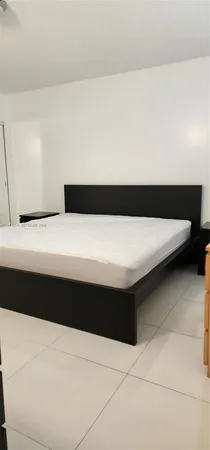 a bedroom with a bed and a night stand