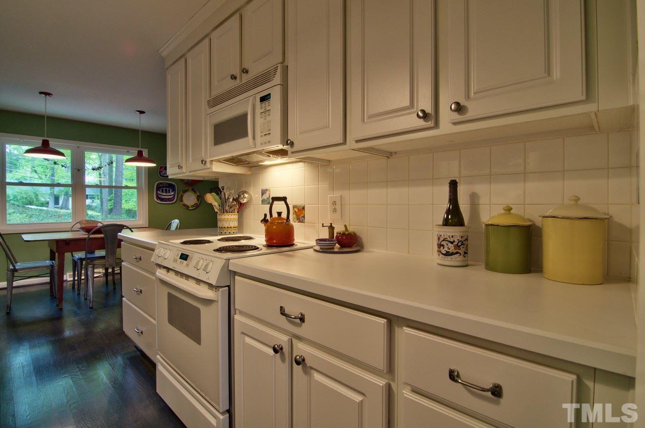 3105 Buckingham Road Durham, NC 27707 - Photo 10 of 25 a kitchen with stainless steel appliances granite countertop a sink a stove and a wooden floors