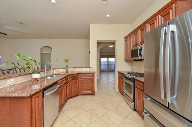a kitchen with granite countertop a sink and stainless steel appliances