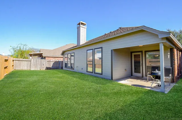 a view of a house with backyard and porch