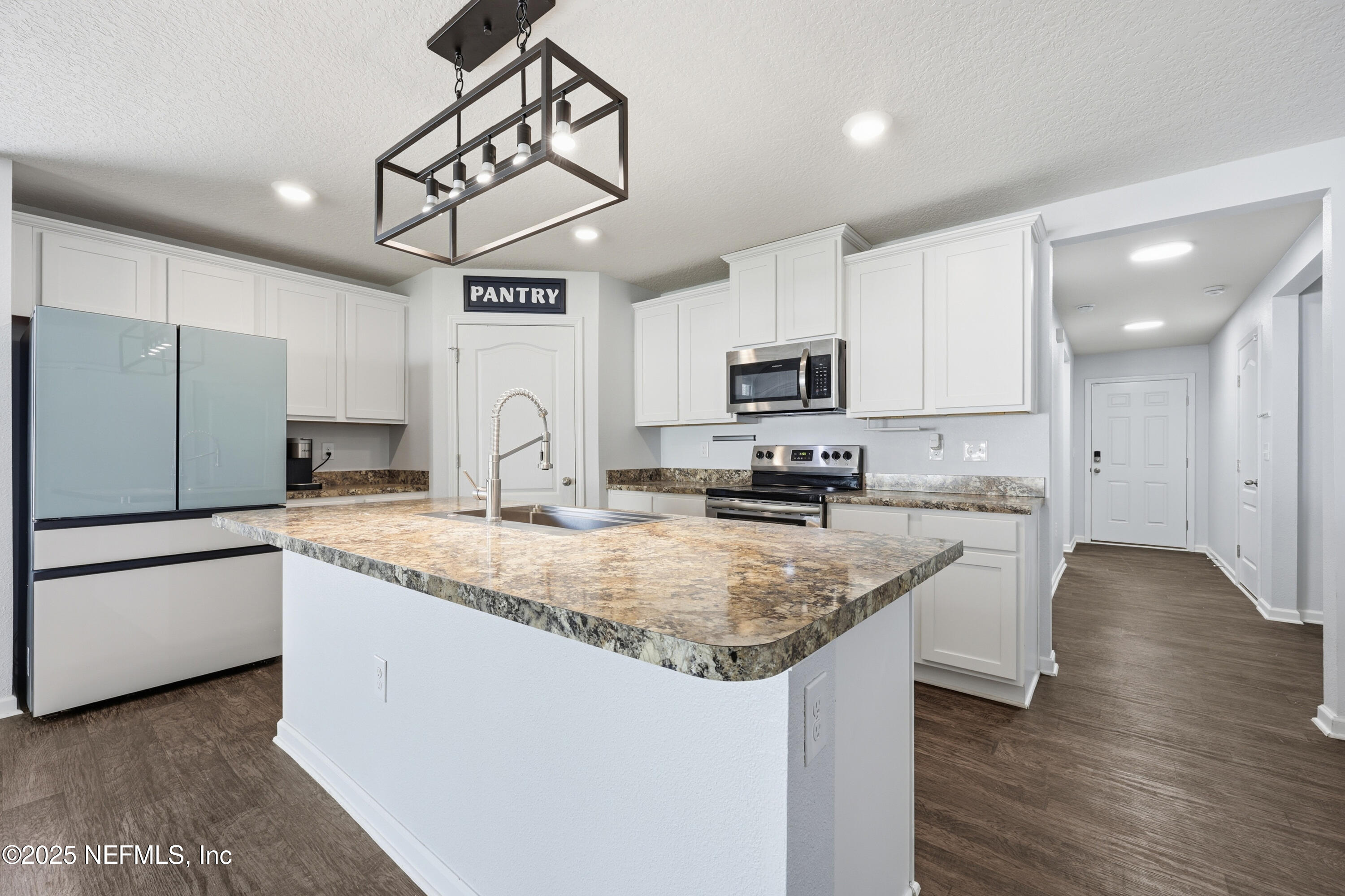 4298 Warm Springs Way Middleburg, FL 32068 - Photo 19 of 36 a kitchen with kitchen island granite countertop a sink appliances cabinets and counter space