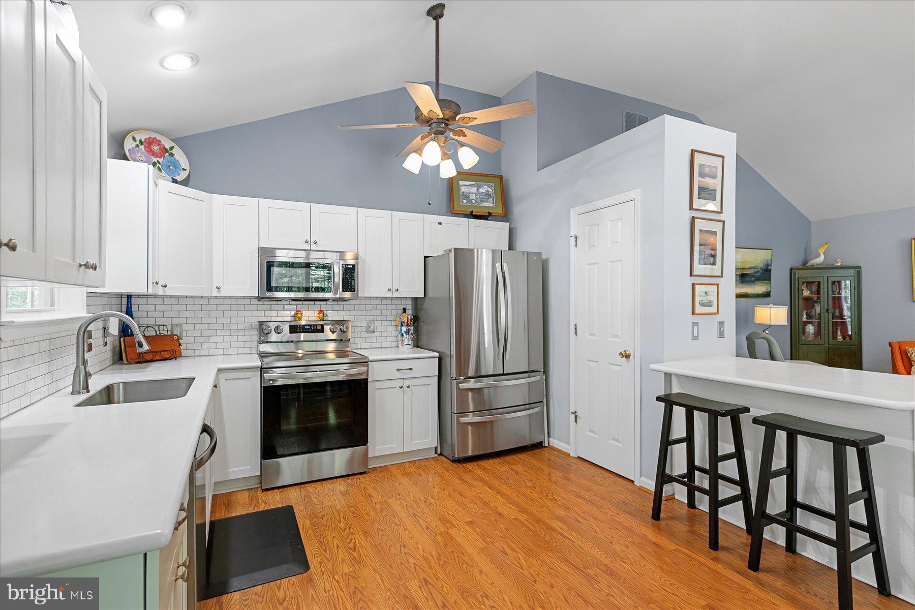 120 Pinehurst Road Berlin, MD 21811 - Photo 10 of 37 a kitchen with stainless steel appliances granite countertop a refrigerator a stove top oven a sink dishwasher and white cabinets with wooden floor