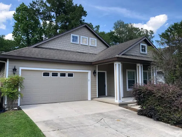 a front view of a house with a garden