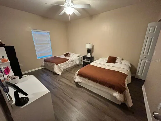 a bedroom with two beds and a desk