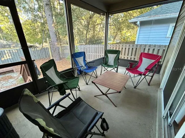 a living room with patio furniture and a floor to ceiling window
