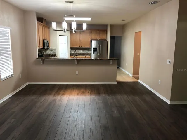 wooden floor in kitchen and a window in an empty room