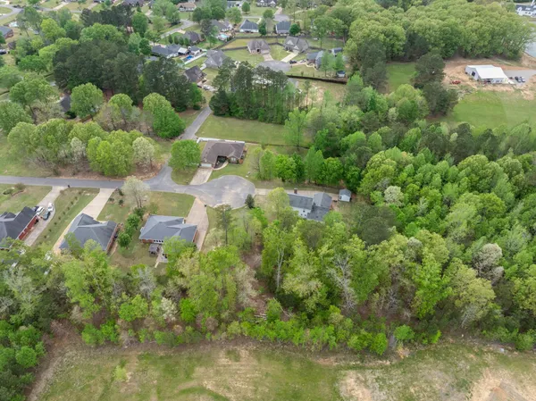 an aerial view of residential house with outdoor space and trees all around