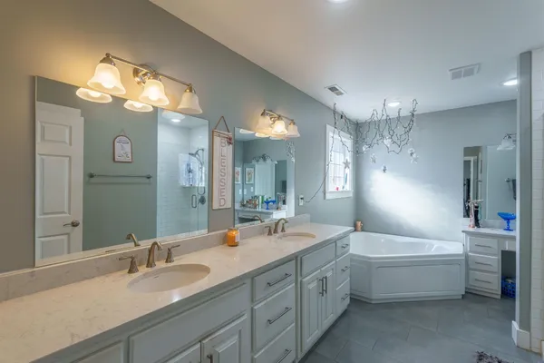 a bathroom with a double vanity sink mirror double vanity and bathtub