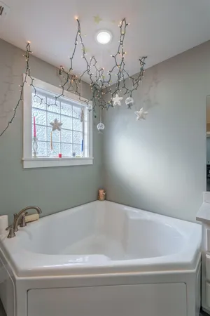 a bathroom with a bathtub and chandelier