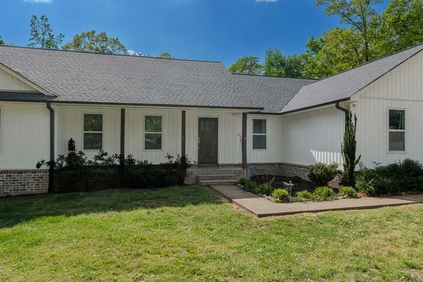 a view of a house with backyard and trees