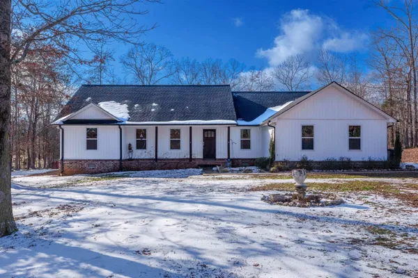 a kitchen with stainless steel appliances granite countertop a table chairs stove and refrigerator