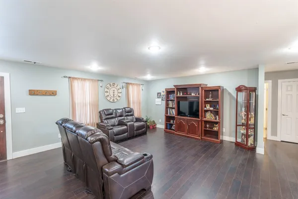 a living room with furniture and hard wood flooring