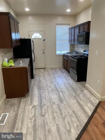 a kitchen with stainless steel appliances kitchen island granite countertop a refrigerator and a stove top oven