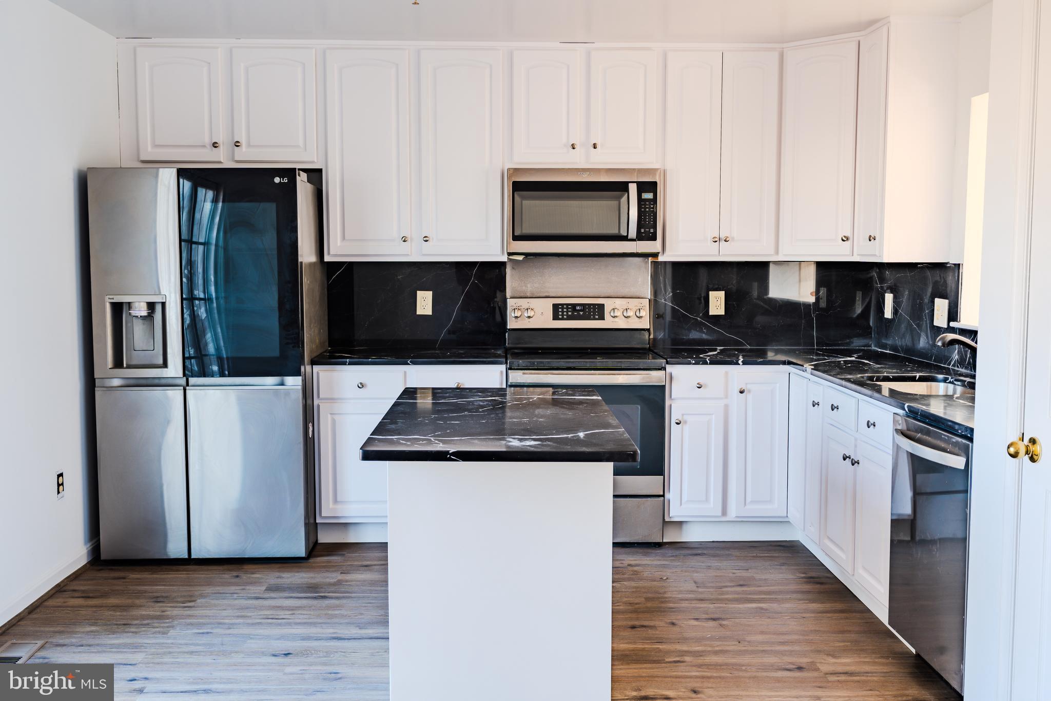 2011 Weitzel Court Frederick, MD 21702 - Photo 19 of 49 a kitchen with white cabinets and stainless steel appliances