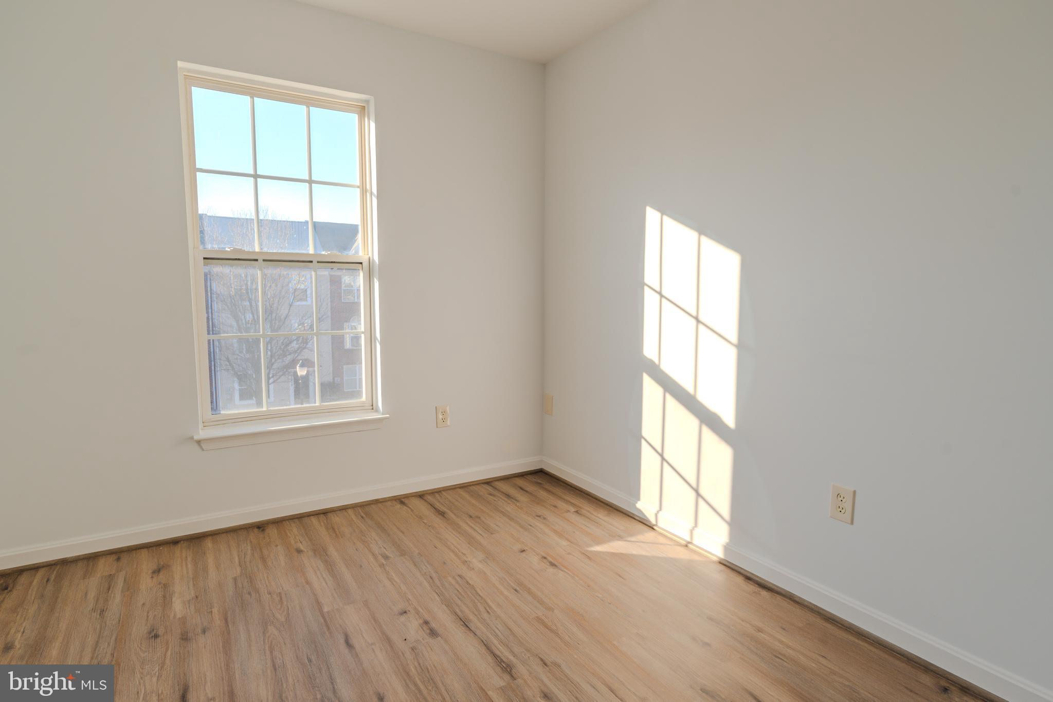 2011 Weitzel Court Frederick, MD 21702 - Photo 37 of 49 an empty room with wooden floor and windows
