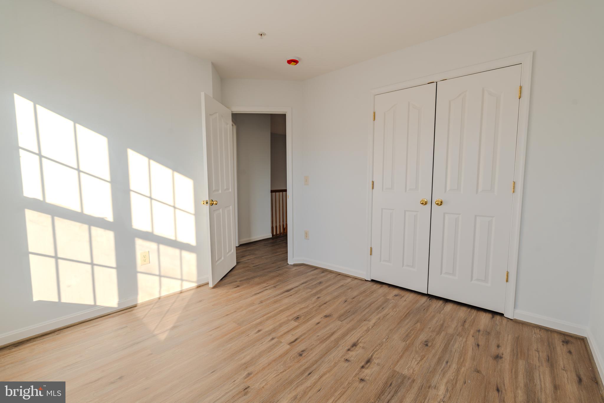 2011 Weitzel Court Frederick, MD 21702 - Photo 7 of 49 a view of an empty room with wooden floor and a window